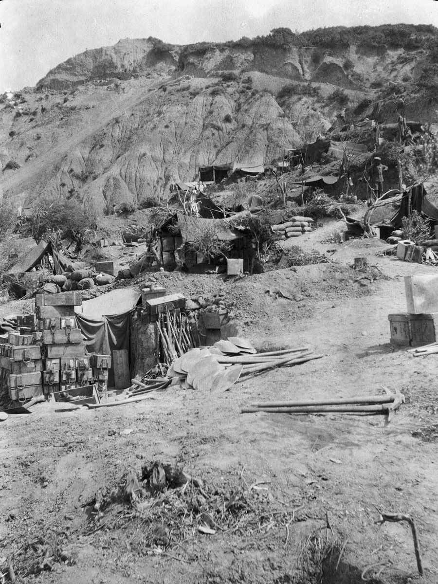View of No 1 Outpost and the top of the hill beyond. The tent roofs of dugout shelters, stores, and tools can be seen in the foreground